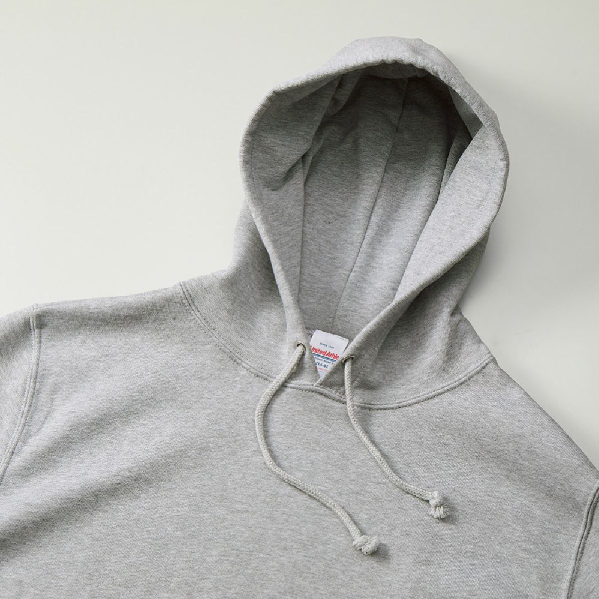 The hood has a double-layered design with no front seams, and the hood drawstring is a round cord in the same color as the body.