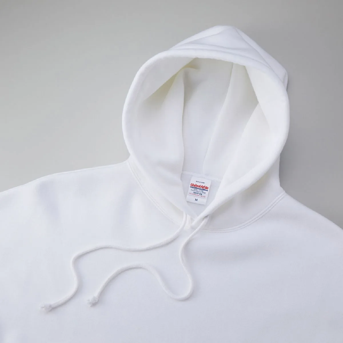 It features a distinctive, oversized double hood, and the hood drawstring is the same color as the body.