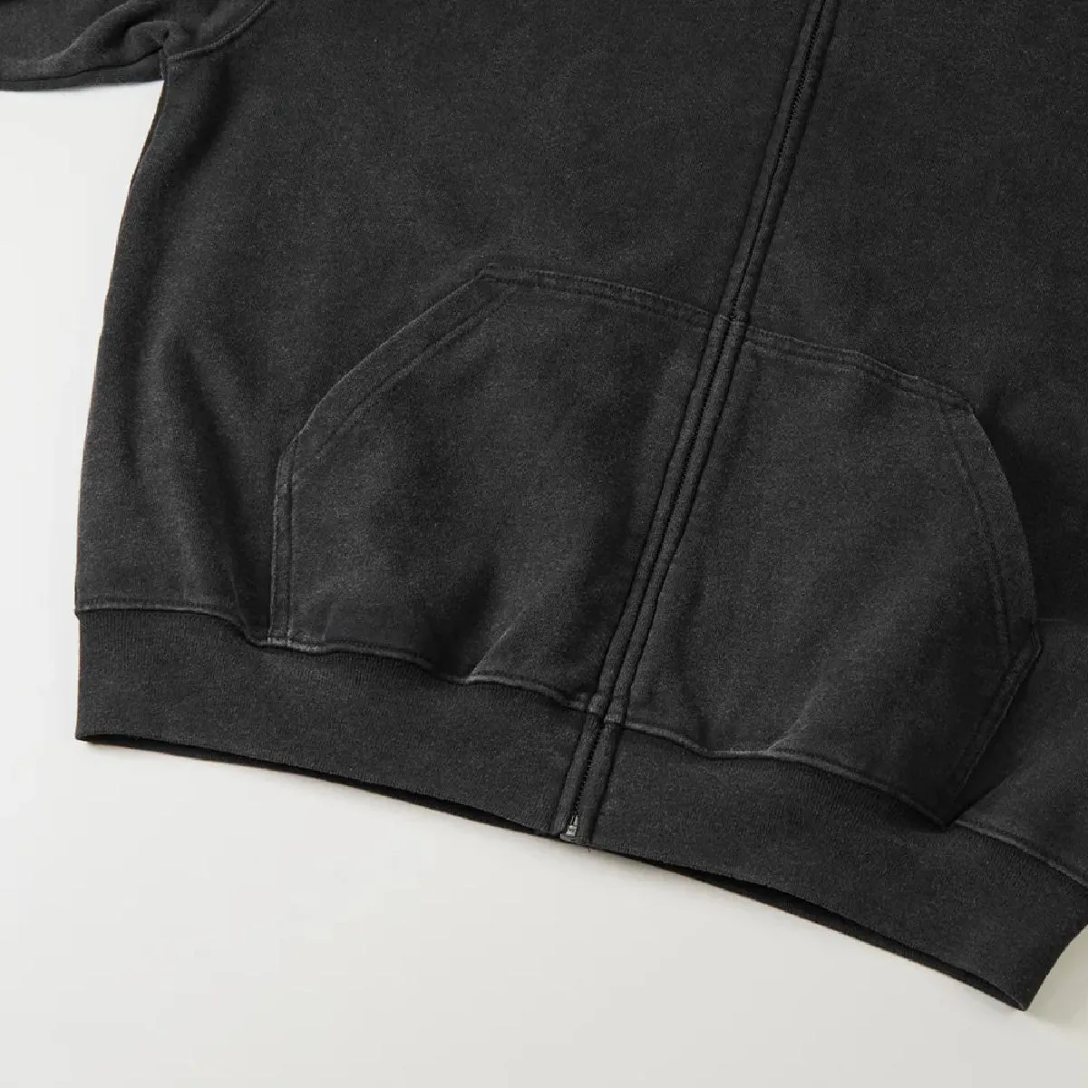 The ribbed cuffs and body seams are finished with a robust double-needle stitching, and the resulting wear marks along the seams create a vintage feel.
