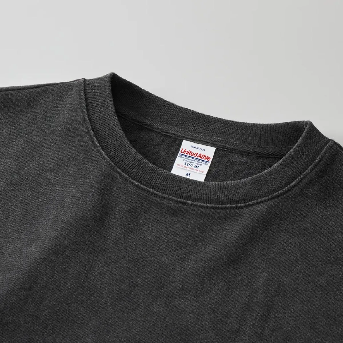 The neck ribbing is finished with double stitching, and the collar tape is made of herringbone tape in the same color as the body, resulting in a durable finish.
