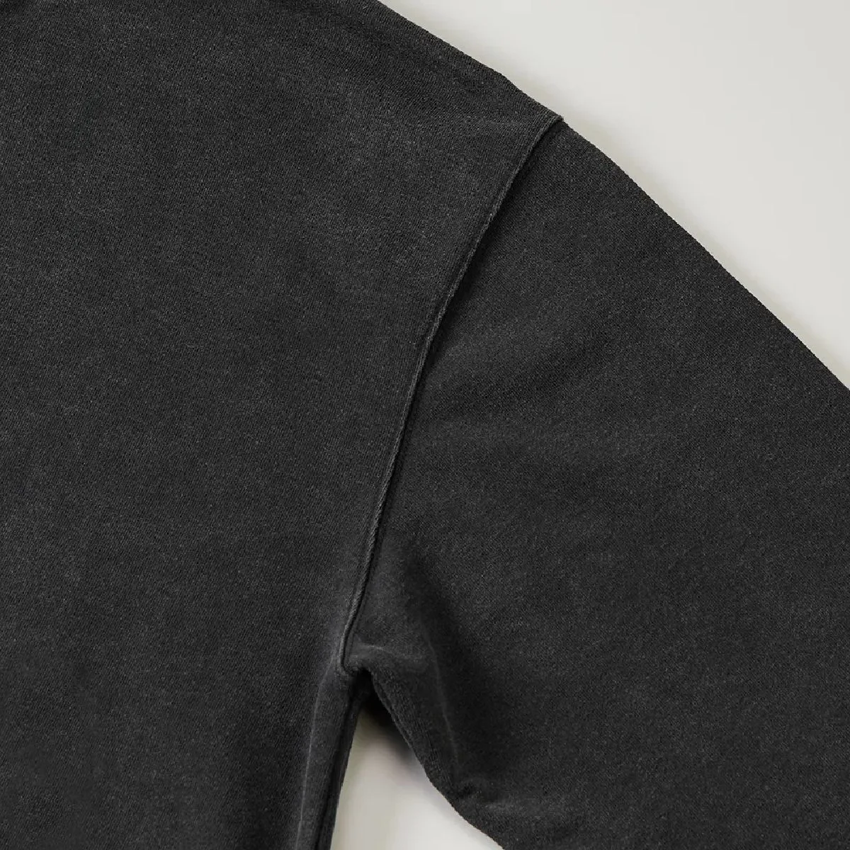 The armholes are finished with a sturdy double-needle stitching, and the resulting wear along the seam line creates a vintage feel.