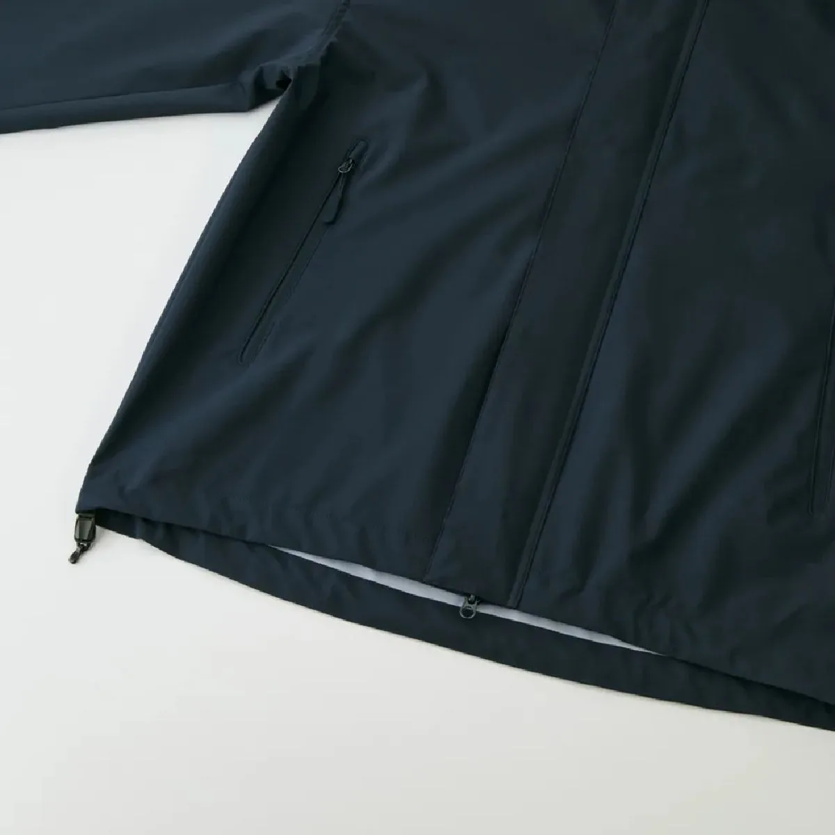 The hem has a drawstring to prevent wind from entering and to adjust the garment's fit and silhouette.