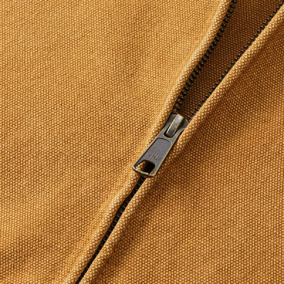 The zipper is concealed, features a single slider from YKK, and is finished in an antique gold color.