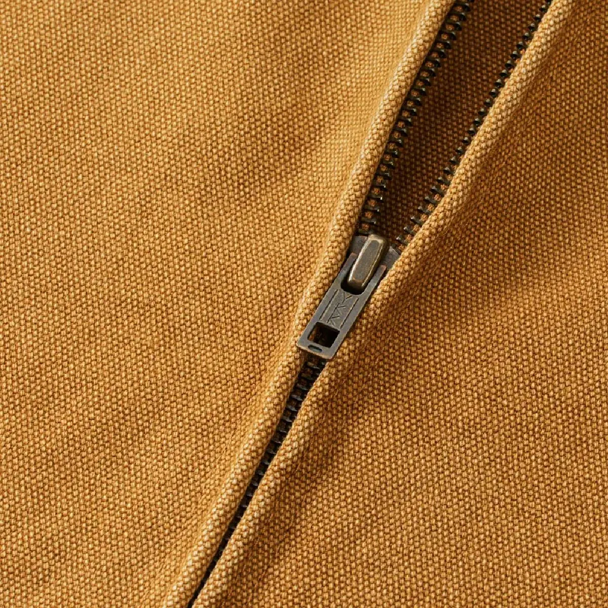 The zipper is concealed, features a single slider from YKK, and is finished in an antique gold color.