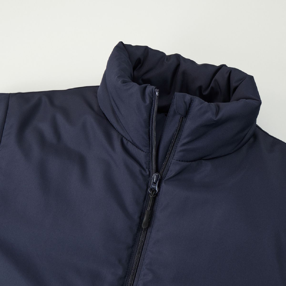 The neckline features a stand-up collar to prevent wind from entering, and includes a chin guard.